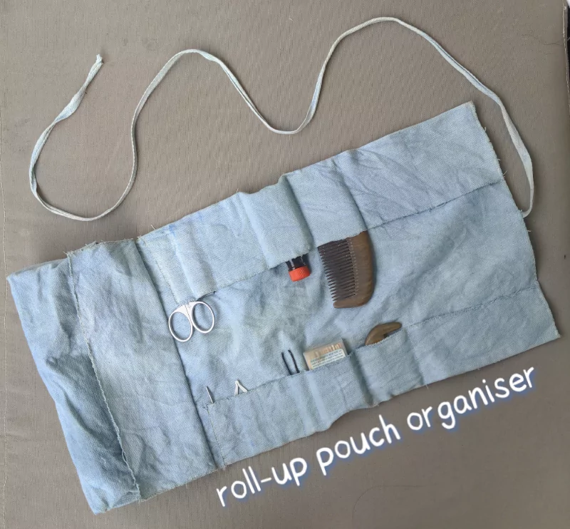 blue roll-up pouch laying flat with toiletries stashed in it