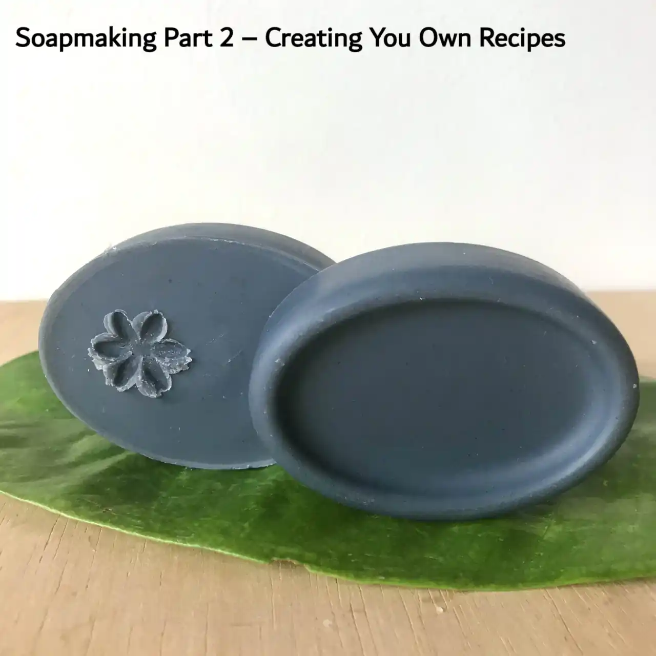 two bars of black charcoal soap sitting on a green leaf as thumbnail for soap guid part 2