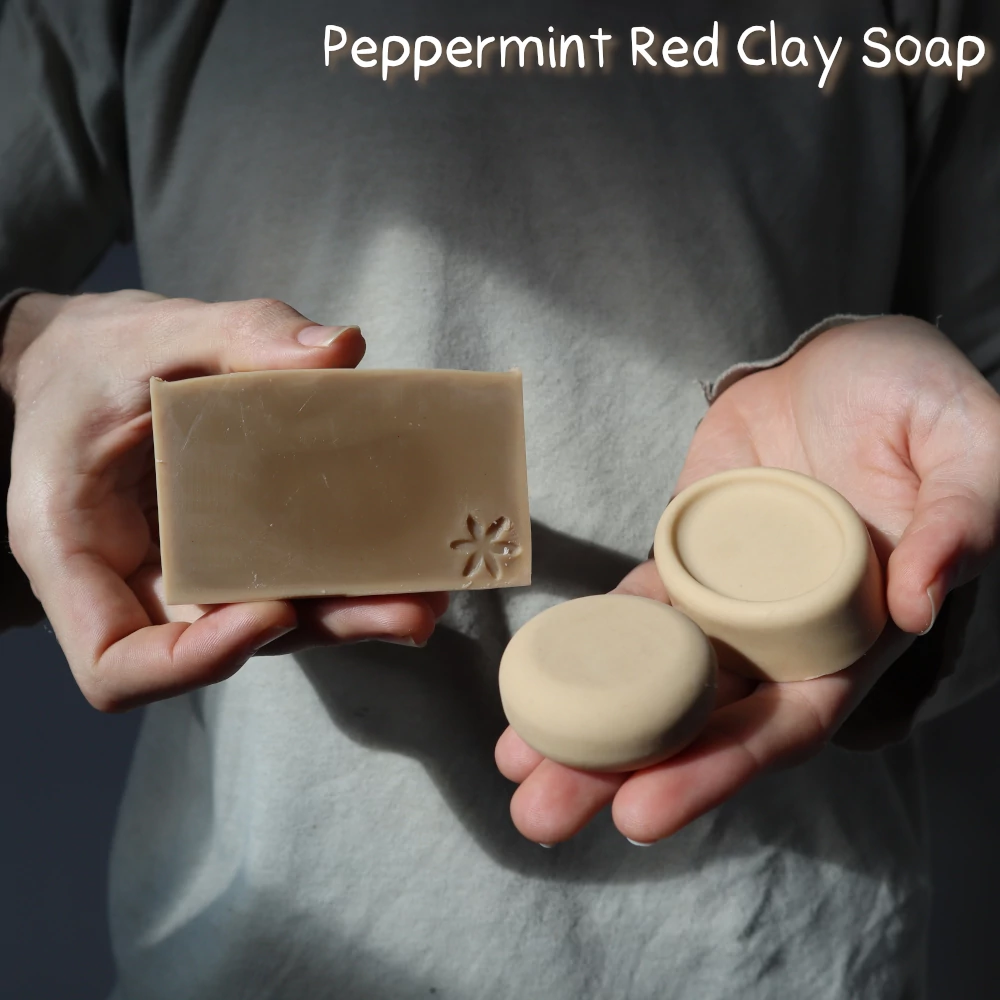 man holding three bars of peppermint red clay 'mighty mint' soap of different shapes in his hands
