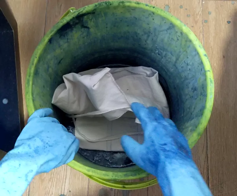 placing roll-up pouch into indigo dye bath