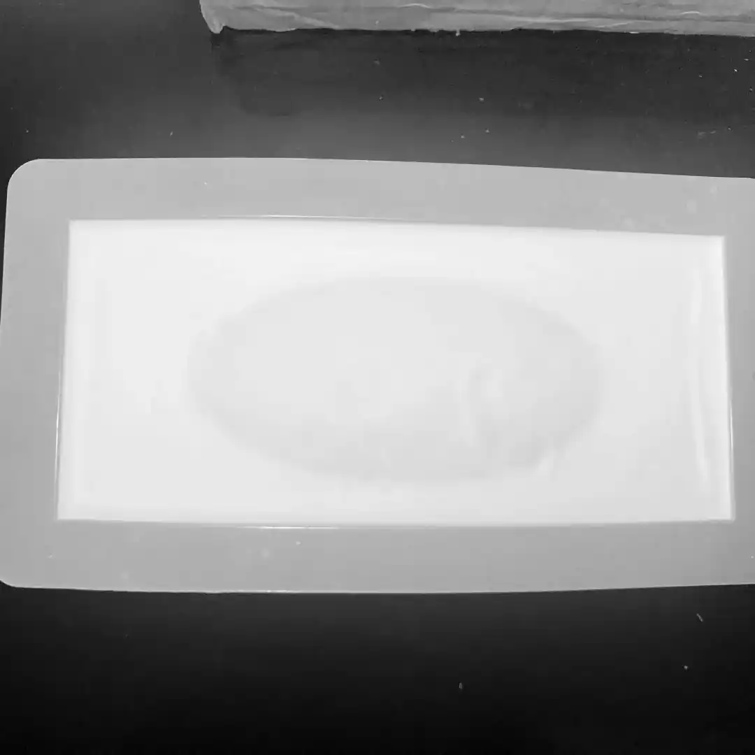 black and white photo showing white soap in regtangle soap mould going through gel phase, there is an oval shaped dark patch in the center of the soap