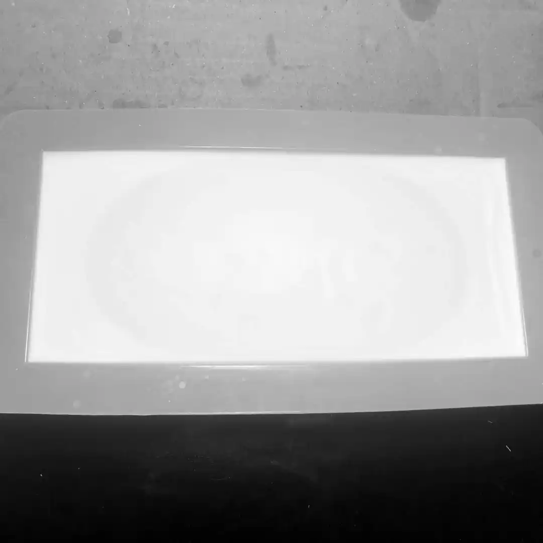 black and white photo showing white soap in regtangle soap mould with dark patch expanding almost to the edge of the mould