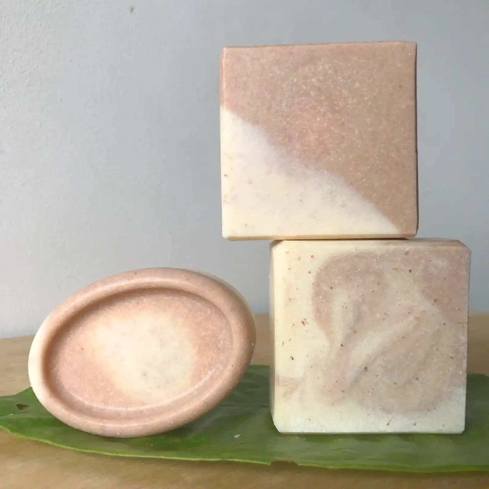 three bars of pink clay soap in redish pink and white colours with swirl patterns