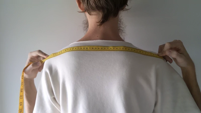 tape measure from tip of one shoulder to the other shoulder